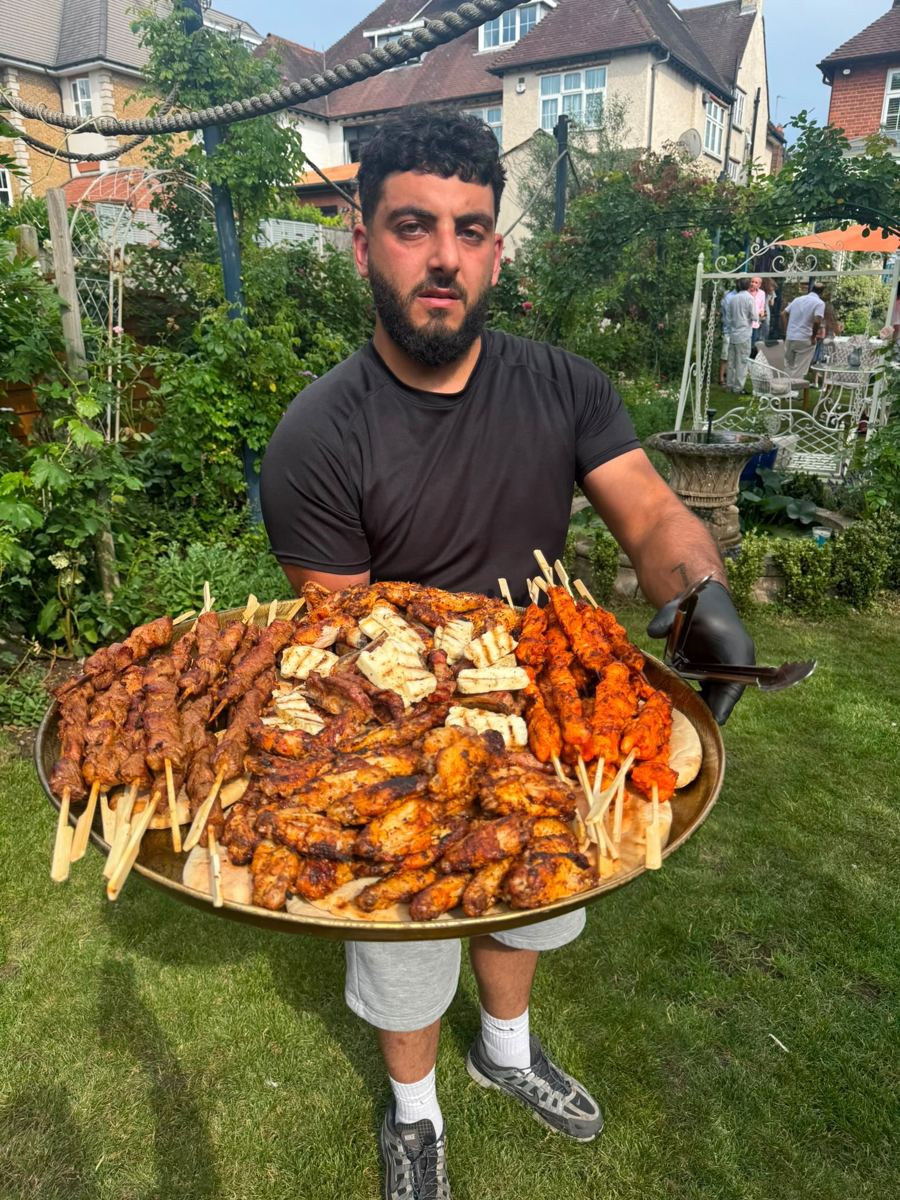 A large platter of chicken shish, lamb shish, wings and halloumi skewers served at a garden party