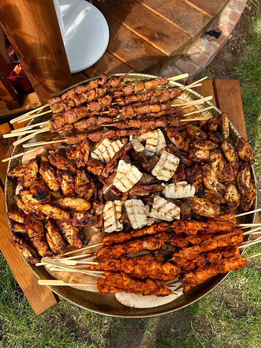 A round platter of grilled chicken, halloumi and shish skewers